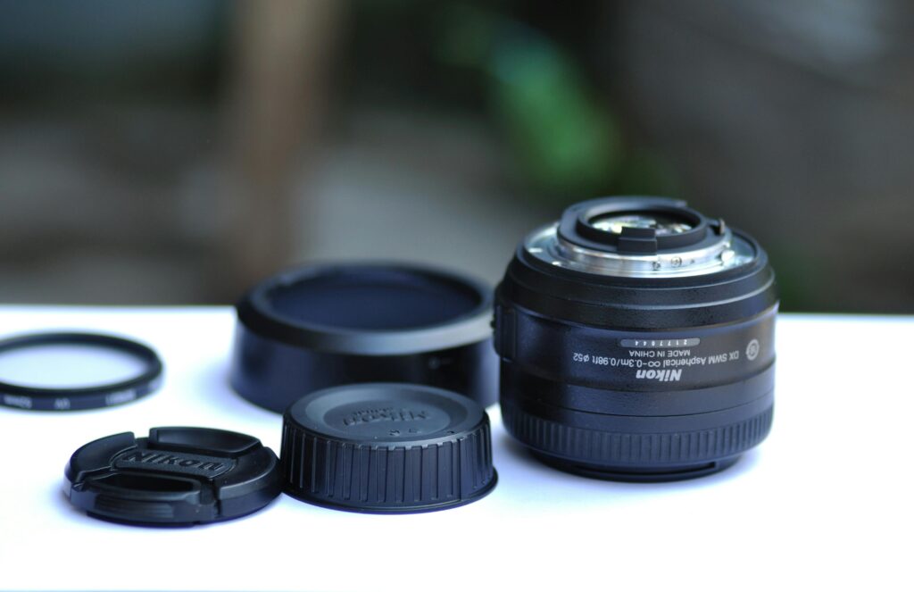 DSLR camera lens with caps and accessories displayed on a white surface, best lens for wedding photography