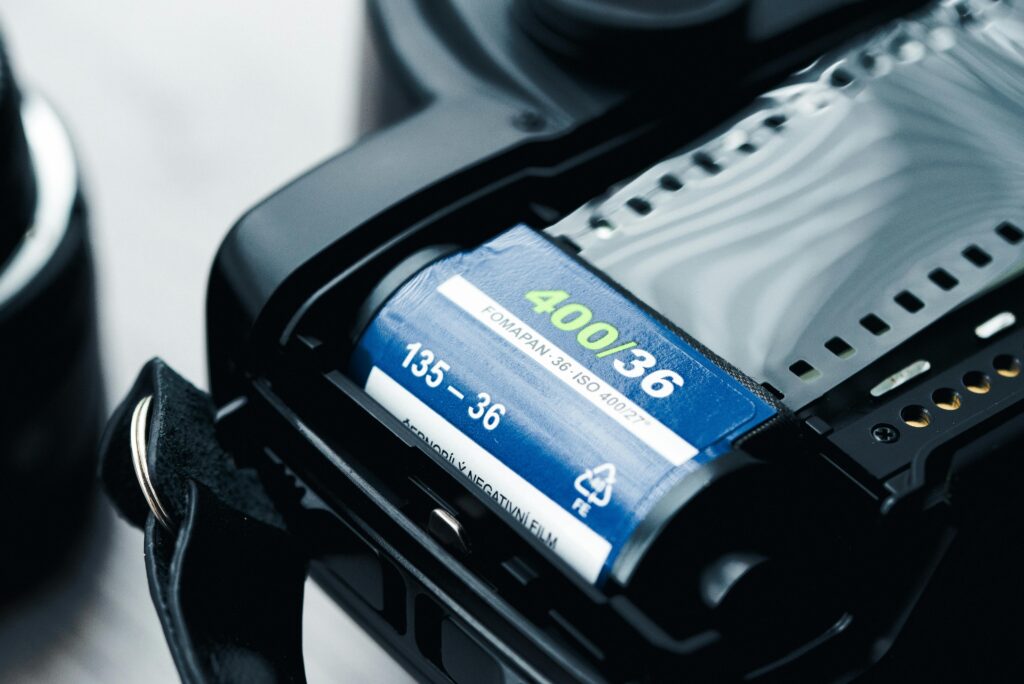 Discover the charm of classic photography with this close-up of a 35mm film roll in a vintage camera.