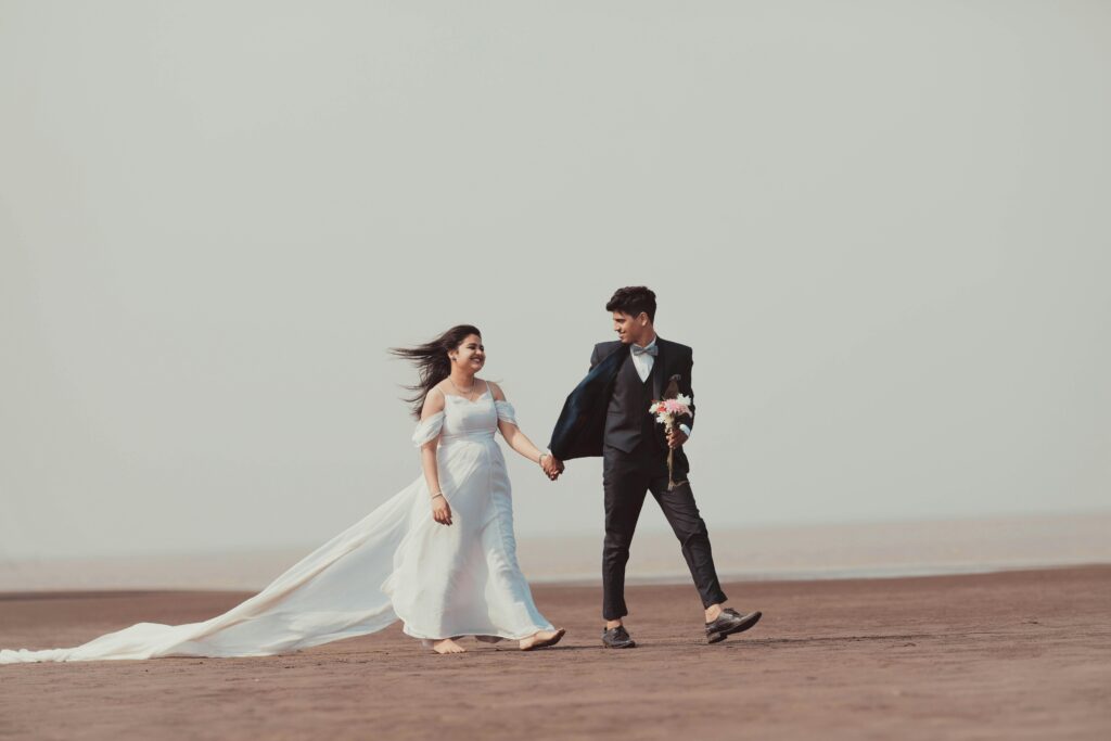 A newlywed Indian couple walking on a serene beach, capturing the essence of romance and togetherness.