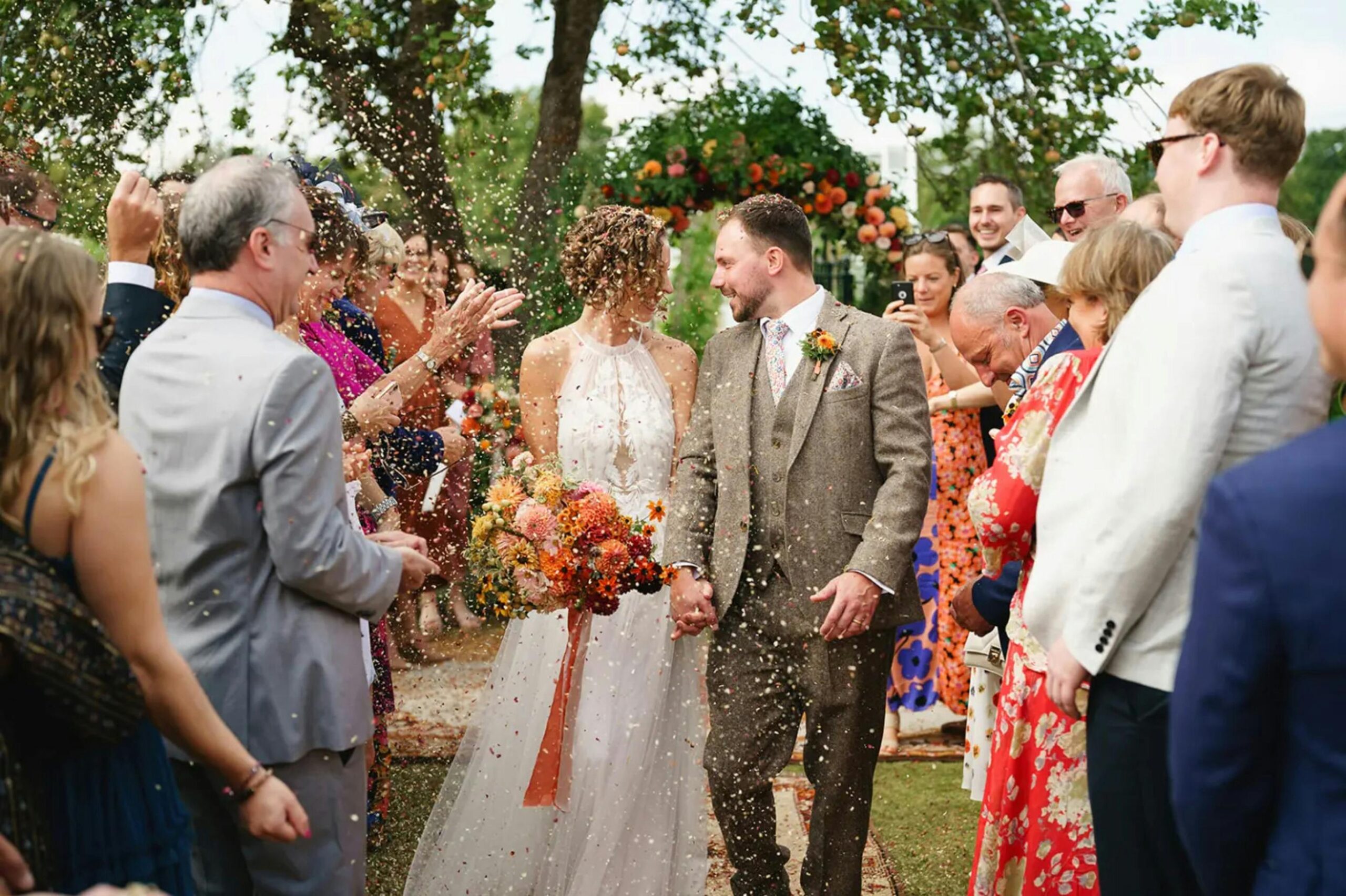 Couple celebrates outdoor wedding in England with family and friends.