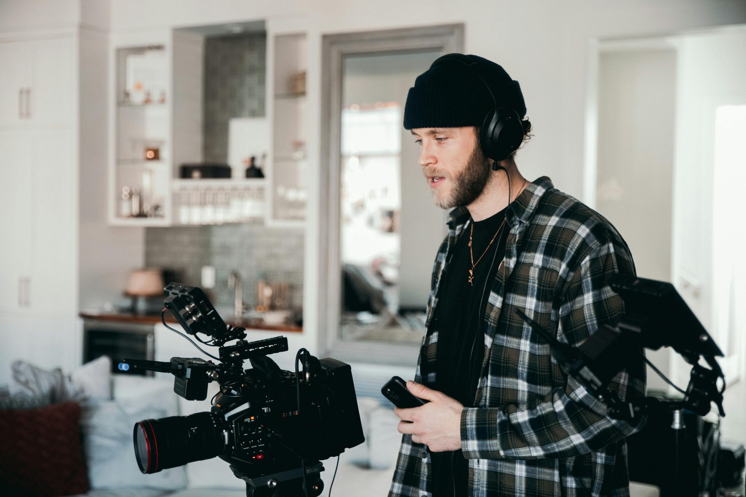 Professional cinematographer working with camera equipment in a modern studio setting.