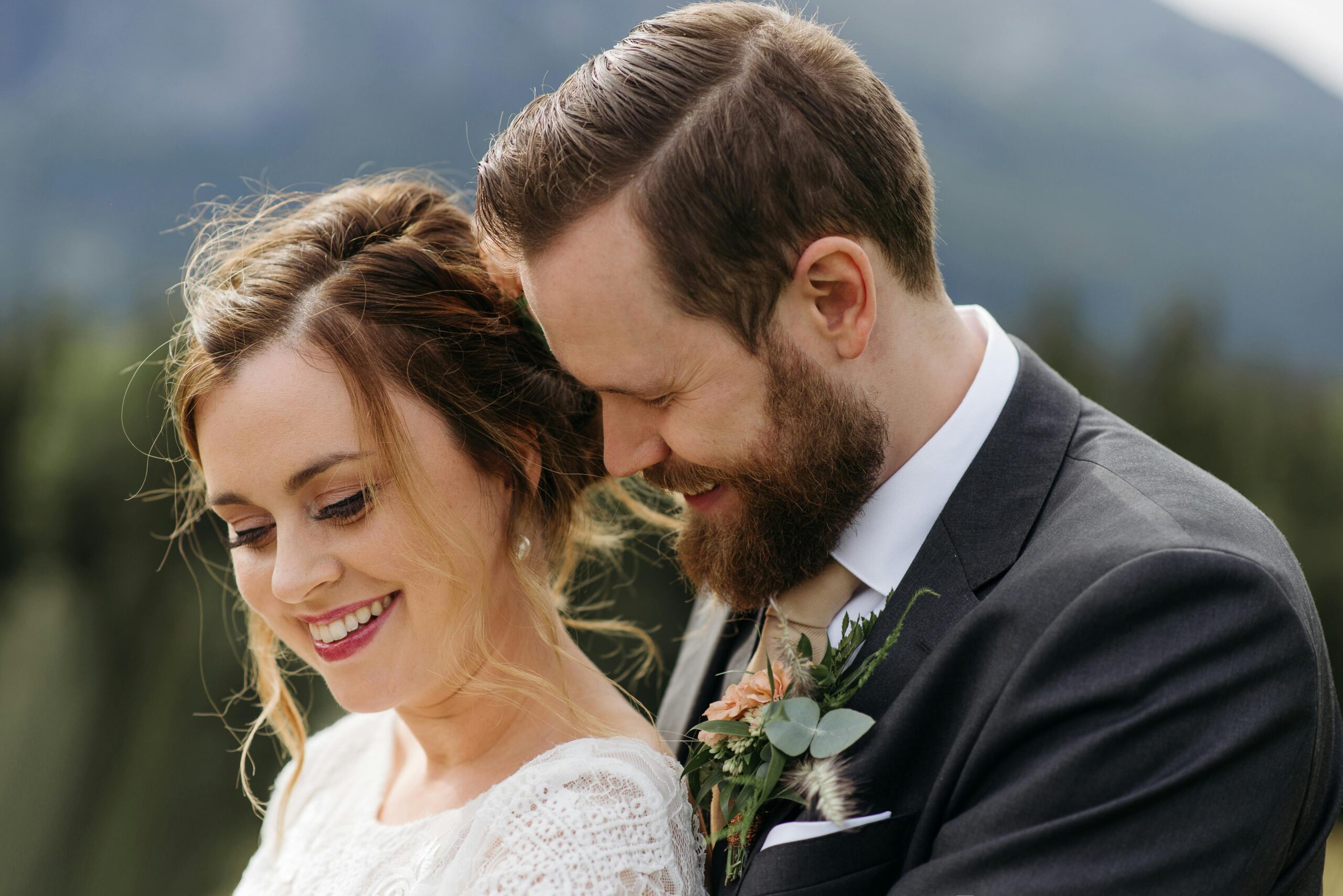 Outdoor wedding portrait of a happy couple embracing in a romantic setting.