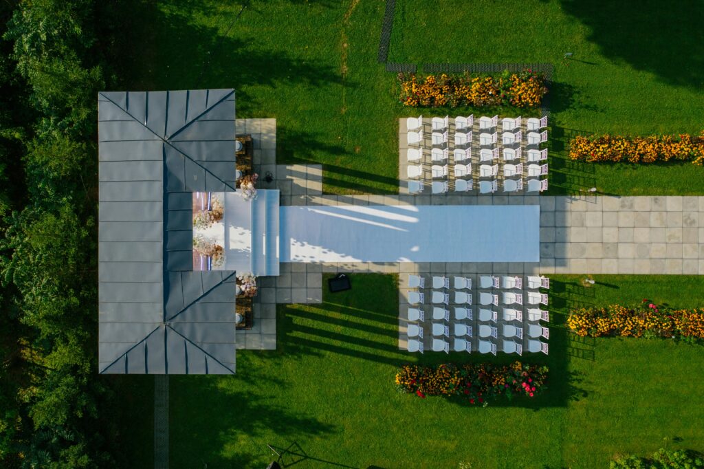 Drone shot of beautifully prepared outdoor wedding venue with chairs and gazebo.